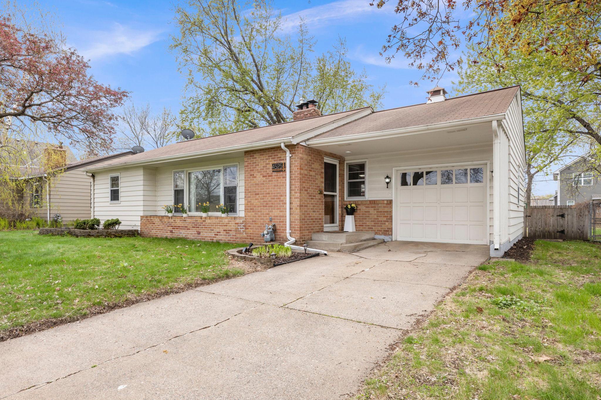 Concrete Driveway with Insulated Garage. Freshly mulched landscaping. Grass blooms fully in May!