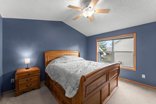 Spacious primary bedroom has a vaulted ceiling, ceiling fan and walk in closet.