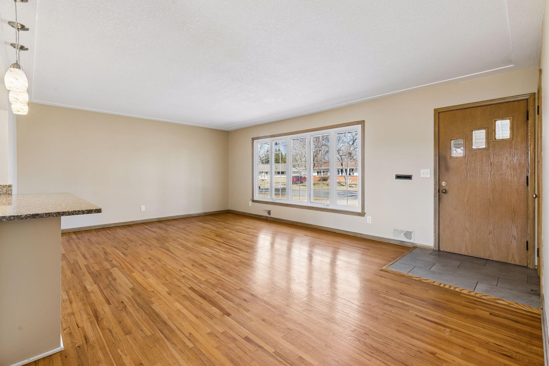The living room features a large window allowing the natural light to pour in.