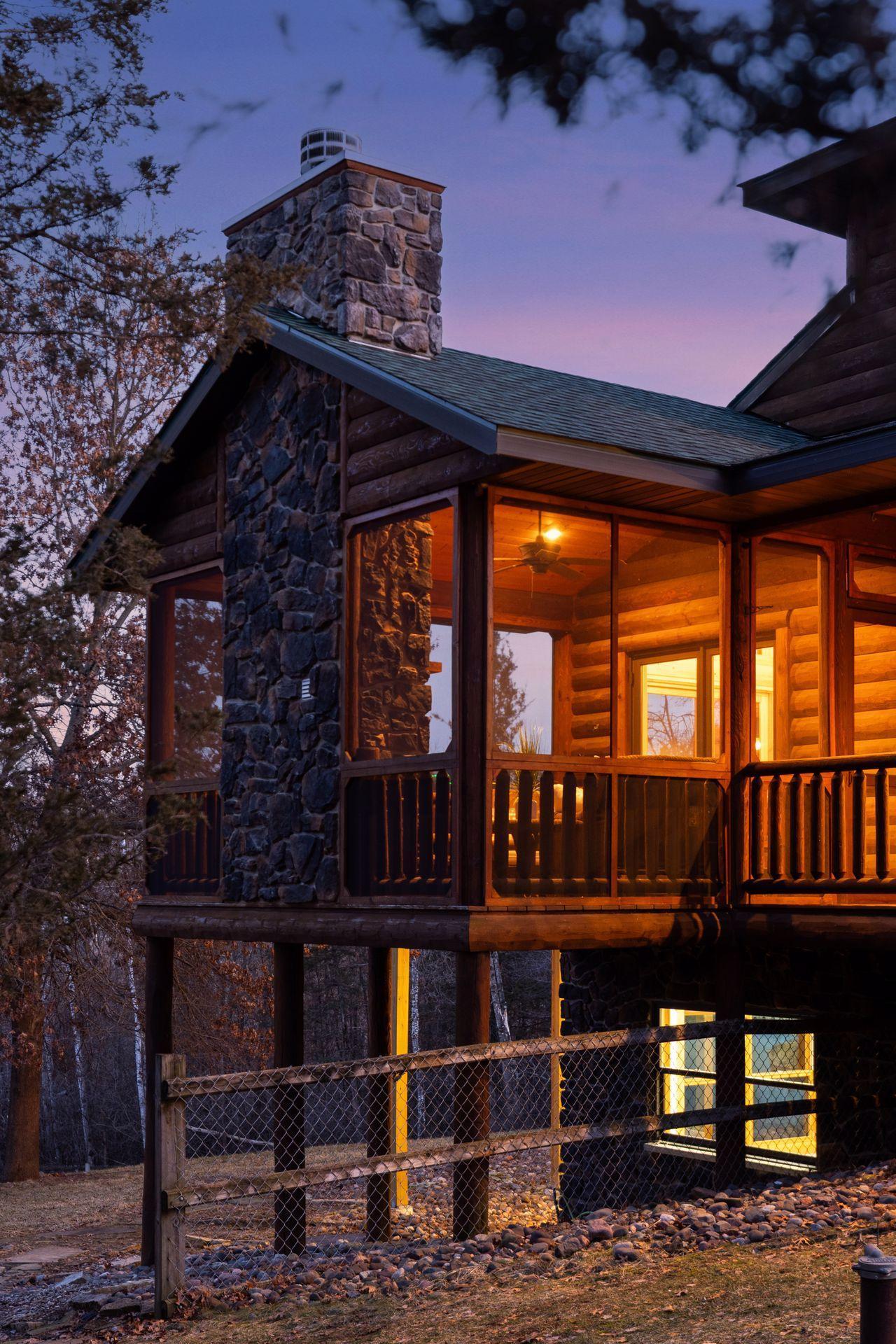 Screened porch with stone fireplace perfect for relaxing and enjoying wooded views