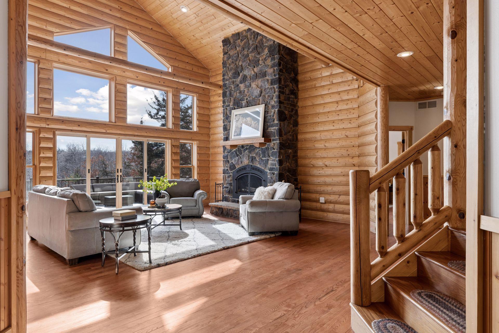 Dramatic great room with soaring ceilings, wall of windows, and floor-to-ceiling stone fireplace