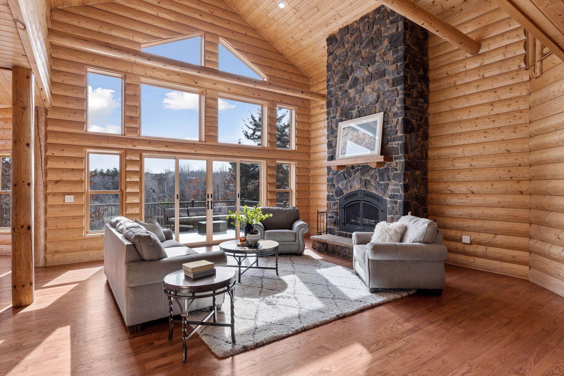 Dramatic great room with soaring ceilings, wall of windows, and floor-to-ceiling stone fireplace