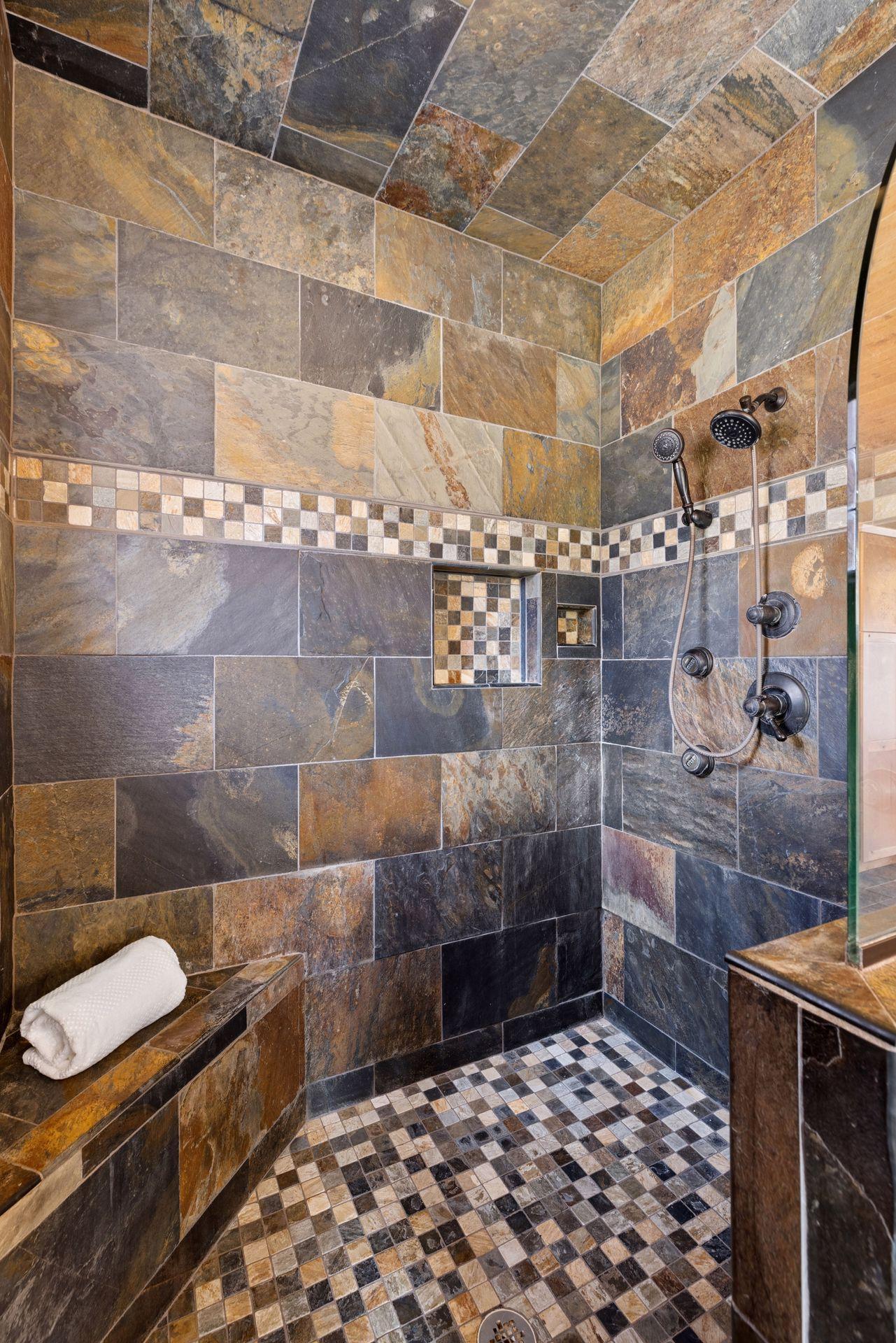 Custom tile walk-in shower with built-in bench and detailed stonework