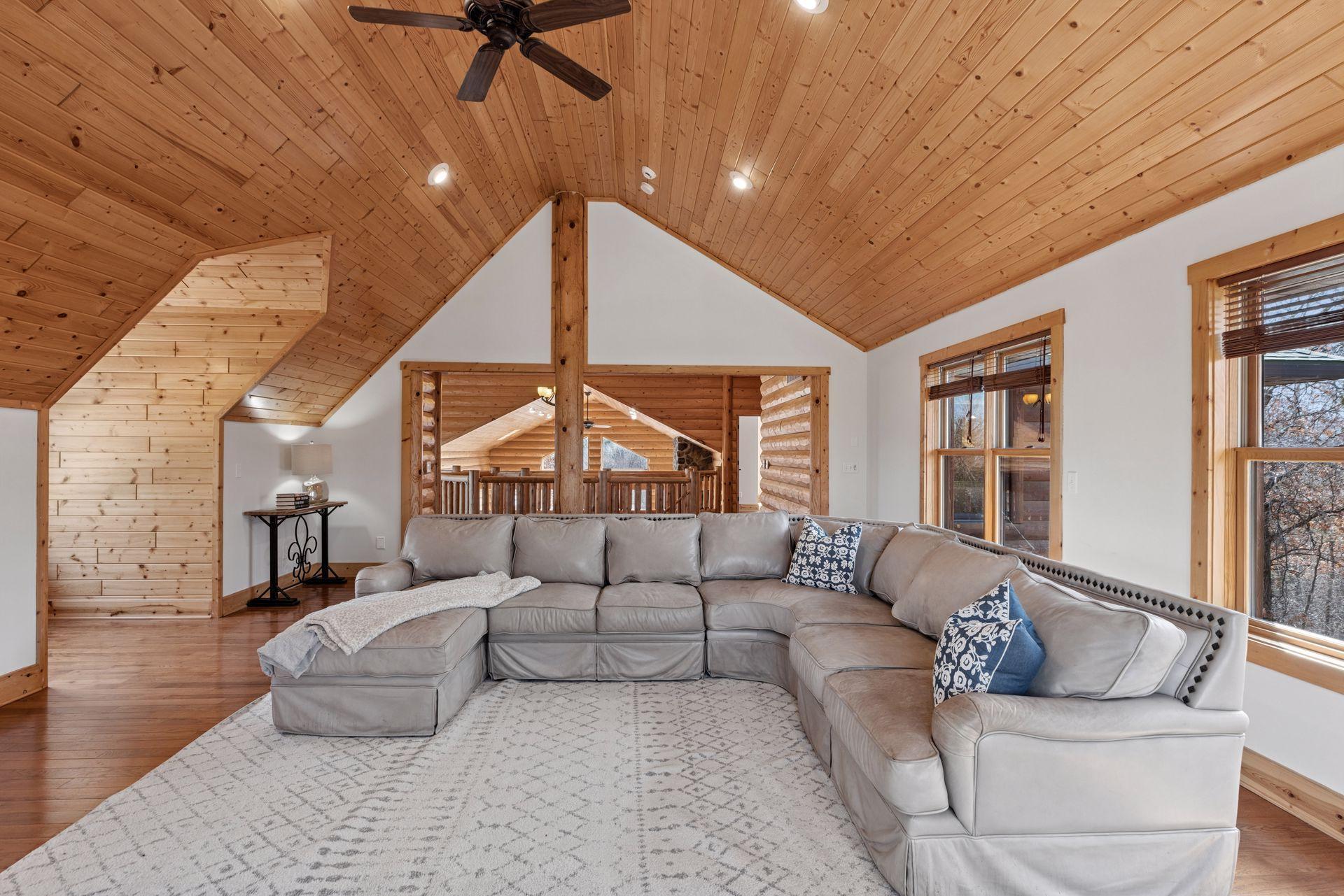 Inviting loft bonus room is a flexible space featuring stone surround wood stove, unique window alcoves, and warm finishes