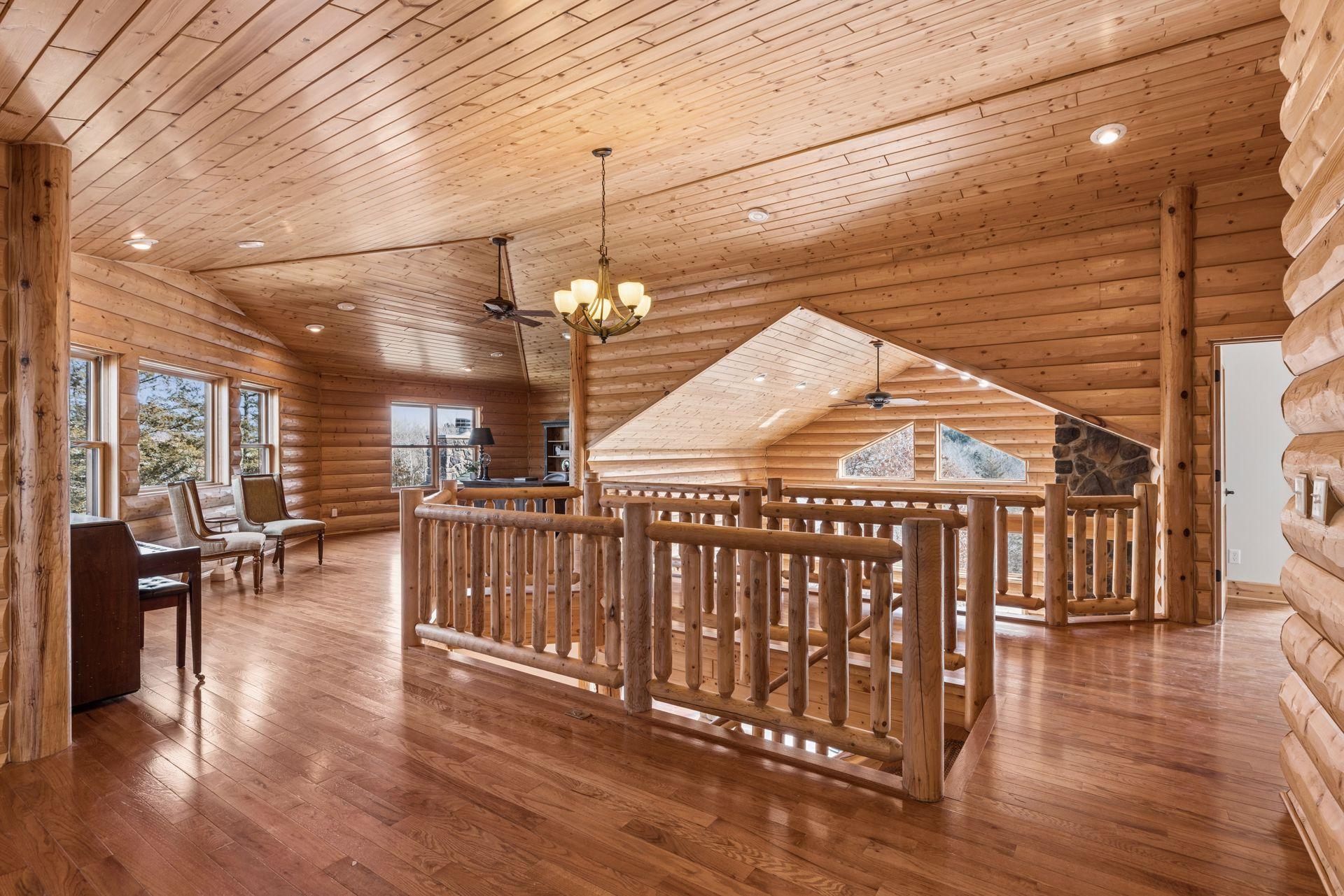 Open loft overlooking the great room with custom log railing and expansive woodwork
