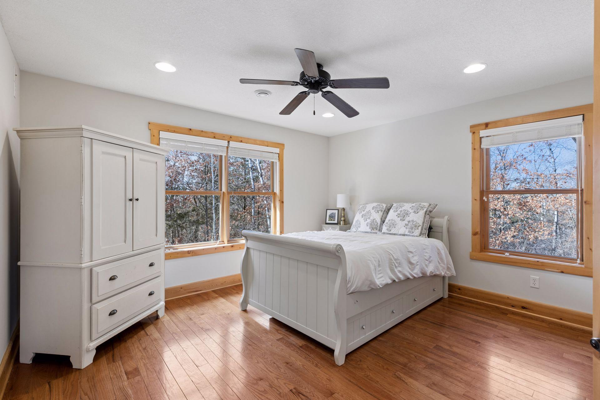 Charming upper-level bedroom with hardwood floors and wooded views