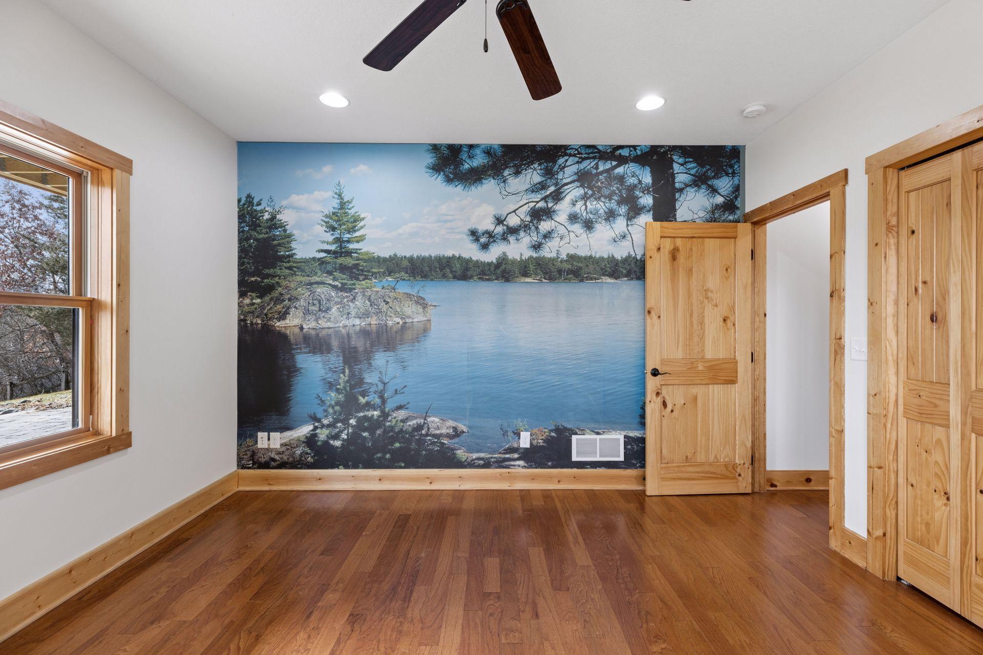 Additional bedroom or flex space featuring hardwood floors and a scenic wall mural for a unique touch