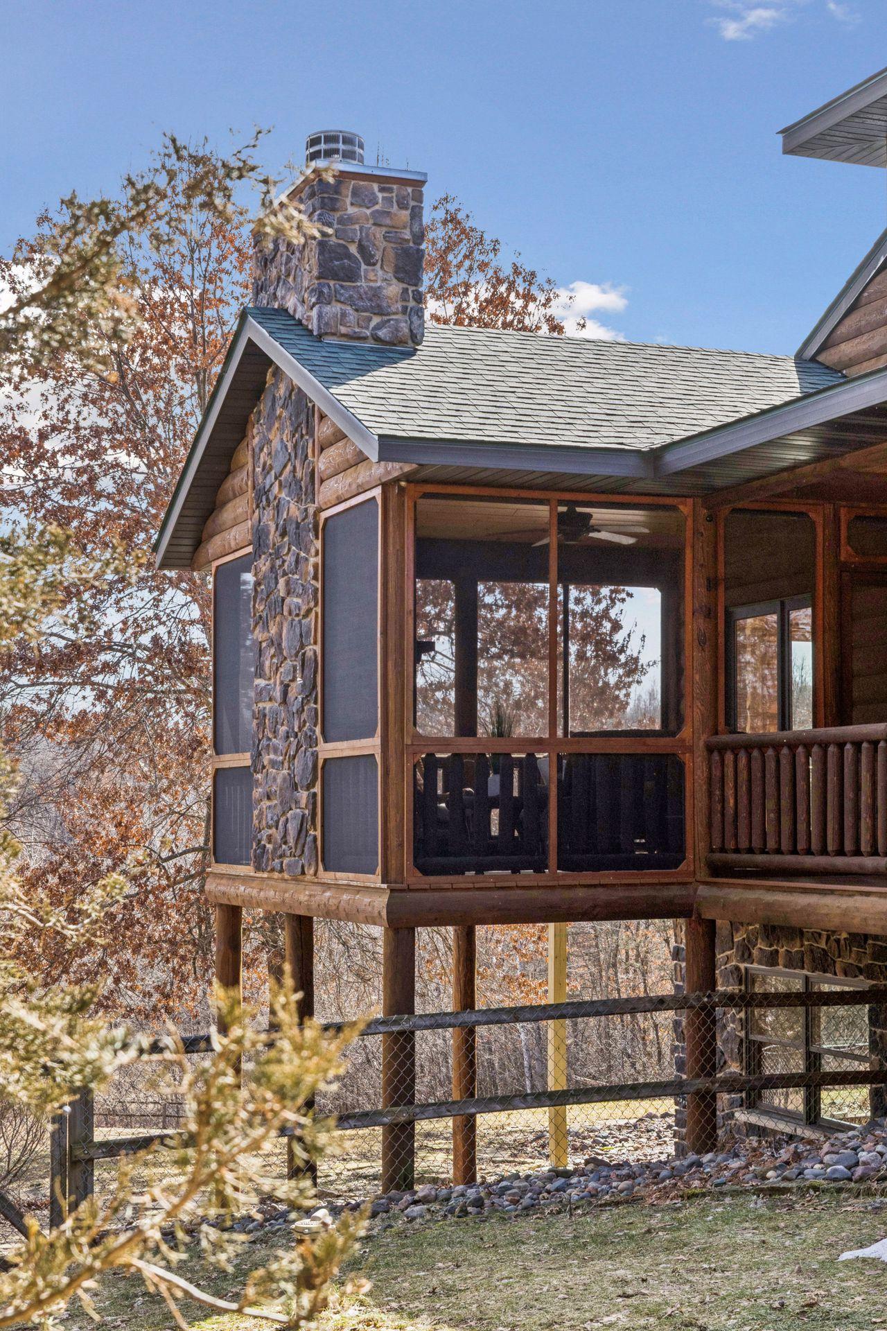 Screened porch with stone fireplace, perfect for enjoying the outdoors in comfort