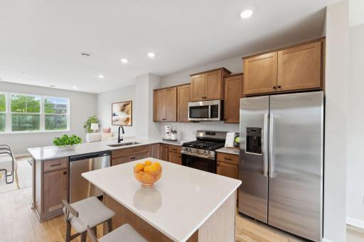 Offering timeless finishes that blend an elevated feel with functionality. The L-shaped kitchen with island and adjacent dining area make a perfect space for both everyday meals and entertaining. Similar home shown.