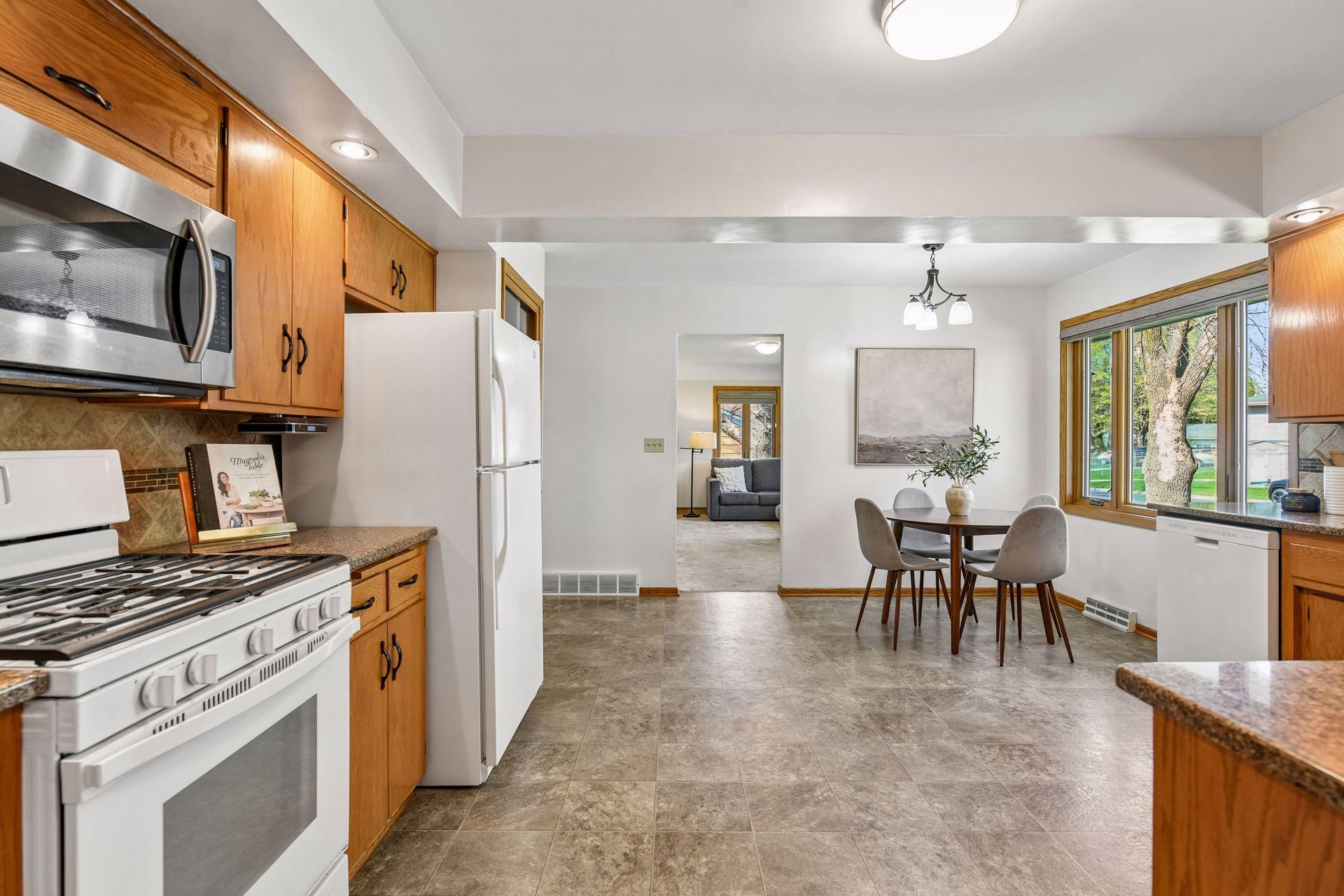 Kitchen and dining room run straight into large living room with windows spanning the entire front.
