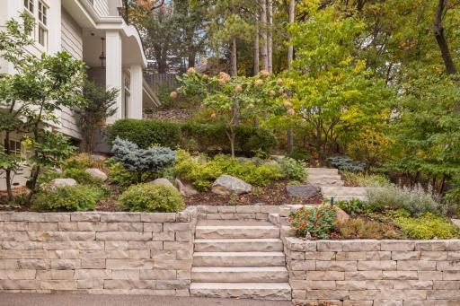 Stone steps and thoughtful landscaping create an inviting entrance