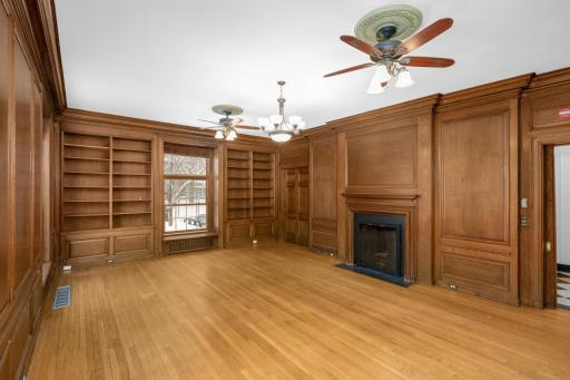 Paneled library or ballroom on main level with patio access. Fireplaces are decorative.