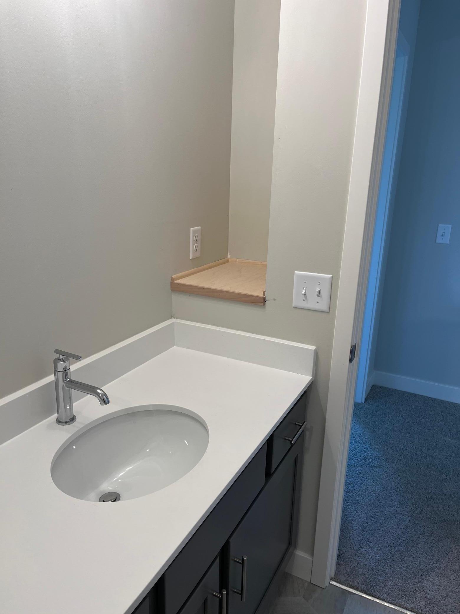 Shelf tucked away in hall bath for additional storage