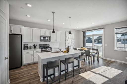 Modern kitchen with stainless steel appliances, quartz countertops, and ample storage. *Photo of actual home, appliances are now stainless steel instead of slate.