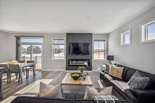 Light-filled living space featuring a cozy fireplace! *Photo of actual home