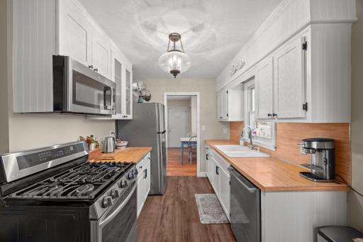 Renovated kitchen with new flooring, updated cabinets, new light fixture, & stainless steel appliances from 2022. Gas range, too!