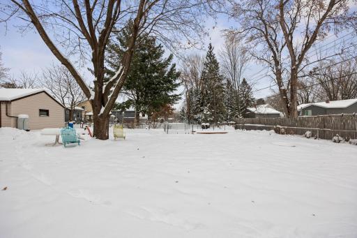 Large backyard has some mature trees and other plantings. Fenced with lots of space.