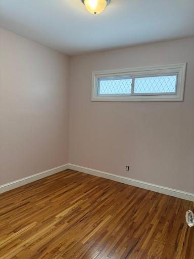 View of the 3rd bedroom. Once again, stunning floors & white trim.