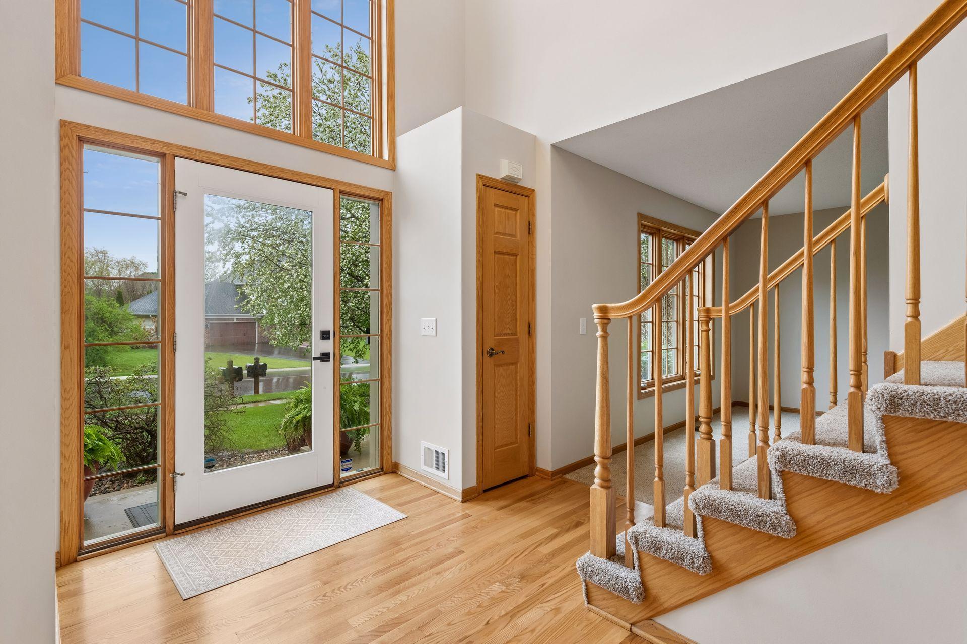 Grand two-story foyer filled with natural light and natural newly refinished hardwood floors.