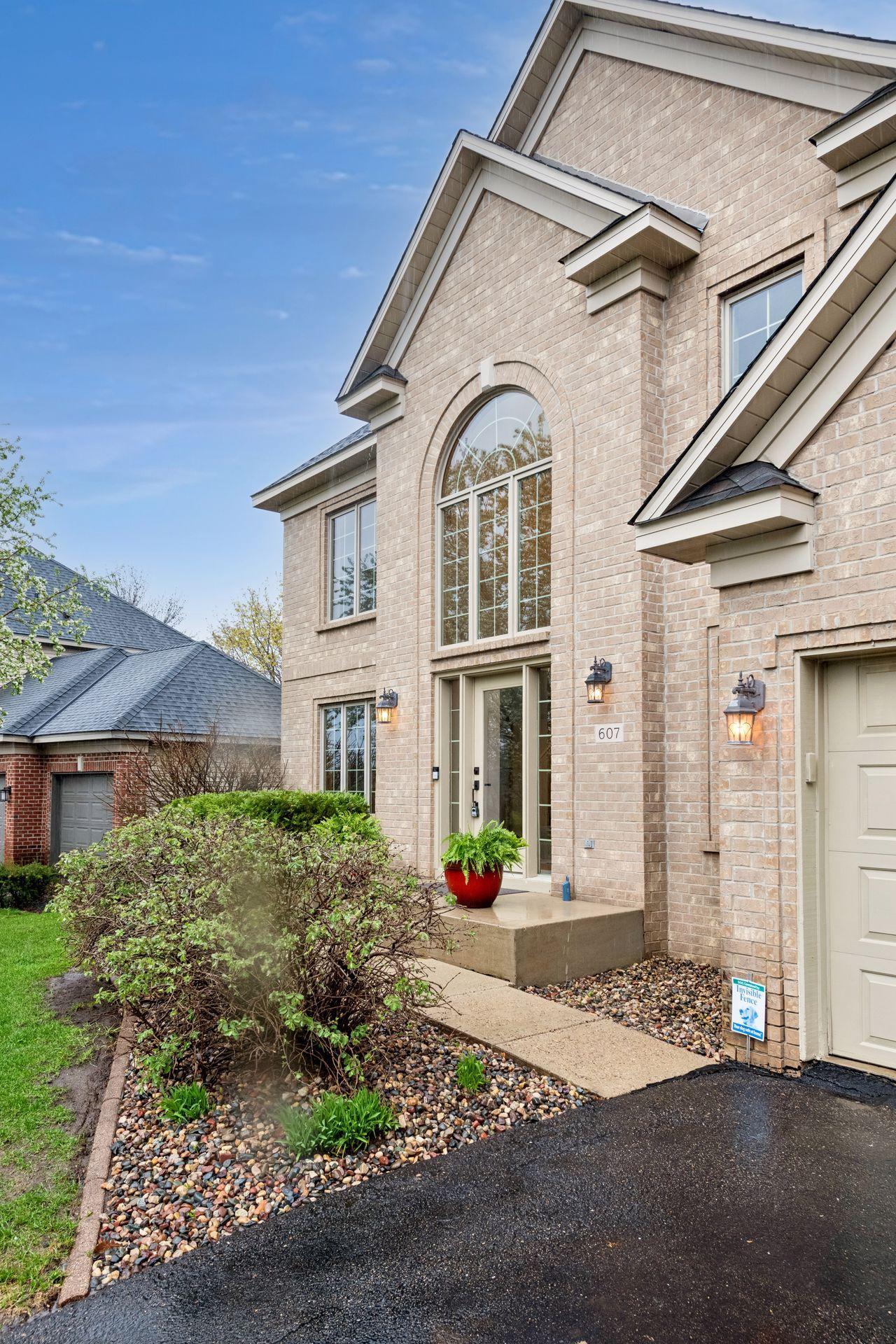 The inviting entryway is surrounded by lush landscaping.