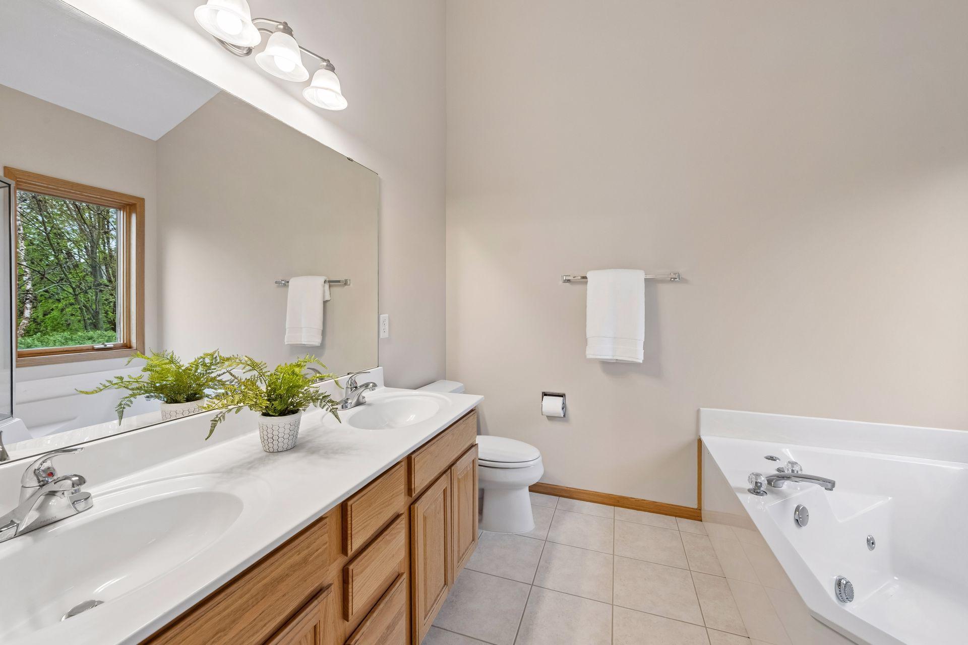 Well-appointed full bath with double vanity and soaking tub