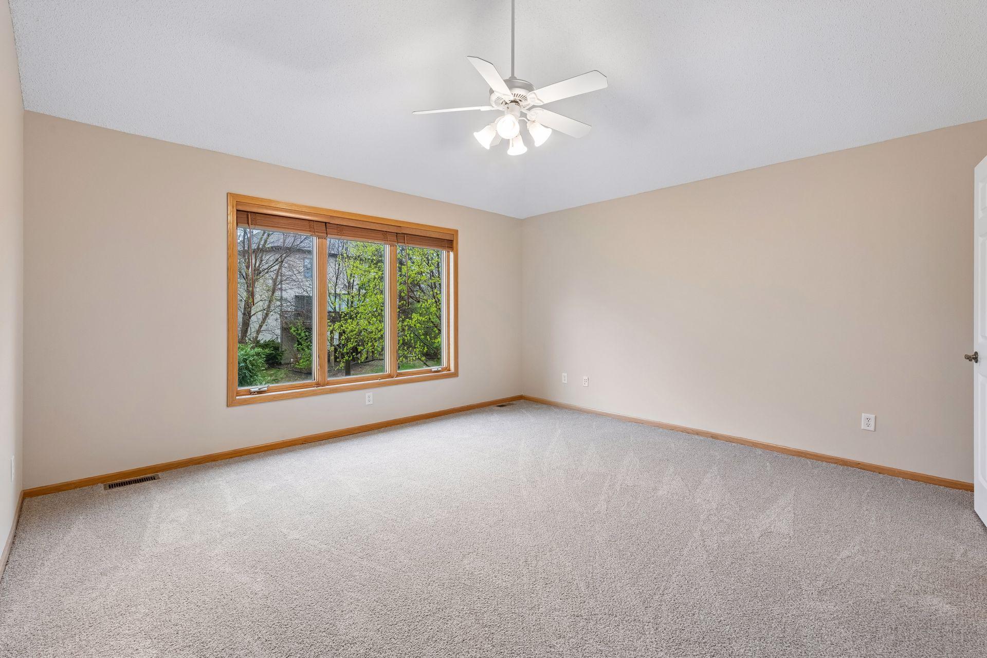 Generous primary suite with vaulted ceiling and expansive backyard views