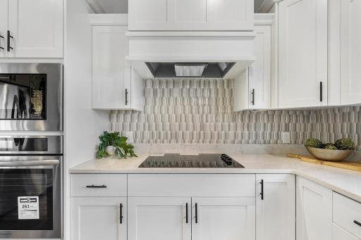 Custom cabinetry with tile backsplash and granite tops