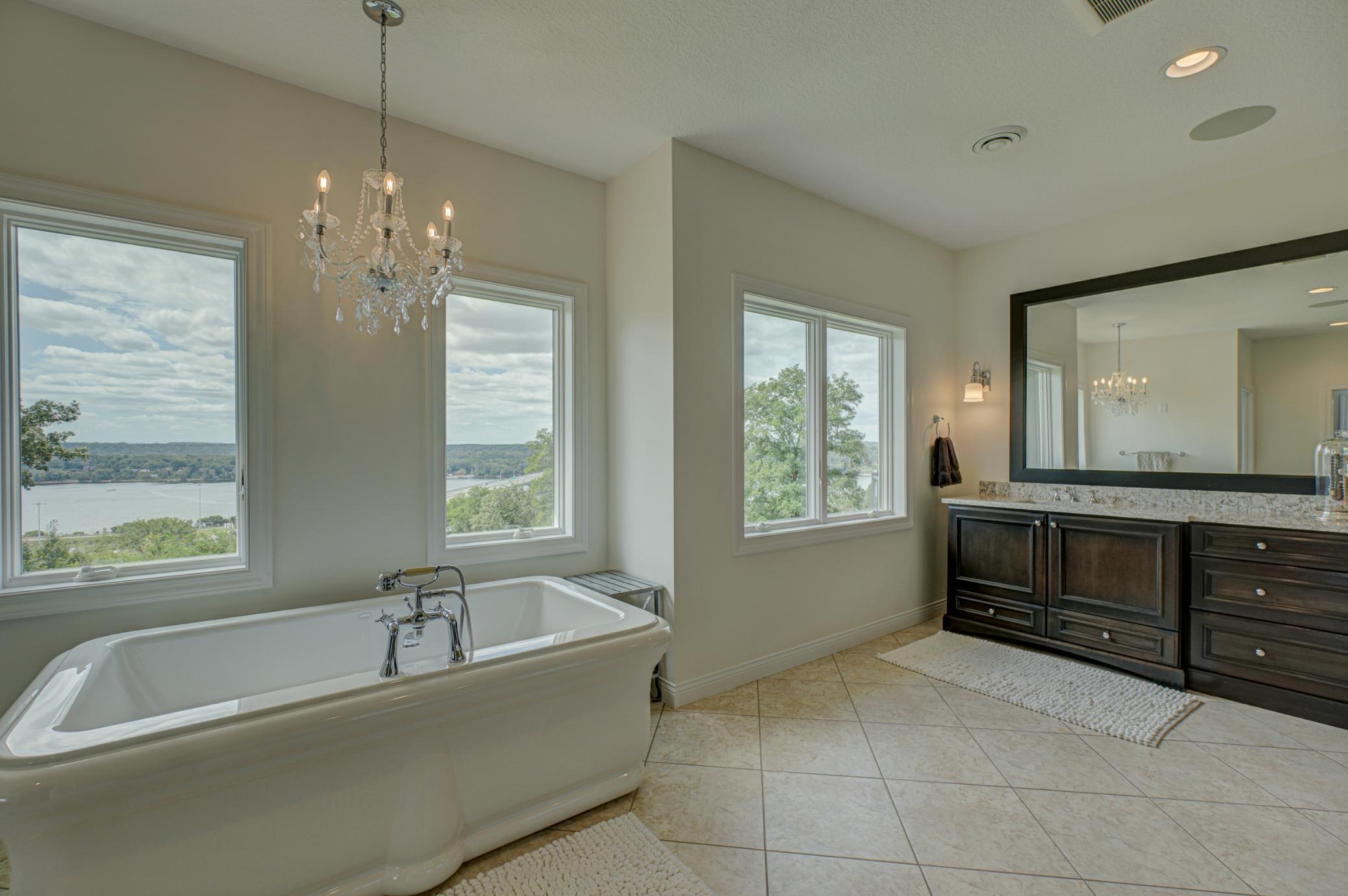 The spa-inspired primary bath features a luxurious soaking tub, a walk-in steam shower, dual granite vanities, and dual walk-in closets with custom built-ins.