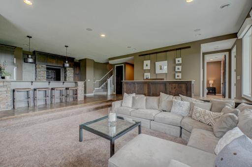 The finished walkout lower level is designed for entertaining, complete with a beautiful kitchen and bar, a luxe wine cellar, sleek stone fireplace, and expansive windows.