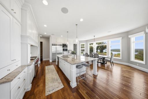 The gourmet kitchen is both expansive and elegant, anchored by a grand center island featuring granite countertops. Professional-grade appliances, including a Sub-Zero fridge & Wolf range, elevate the space.