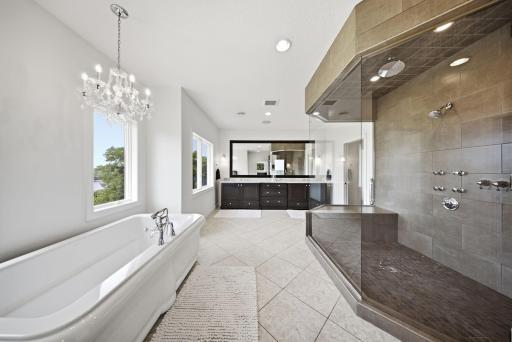 The spa-inspired primary bath features a luxurious soaking tub, a walk-in steam shower, dual granite vanities, and dual walk-in closets with custom built-ins.