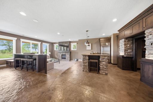 The finished walkout lower level is designed for entertaining, complete with a beautiful kitchen and bar, a luxe wine cellar, sleek stone fireplace, and expansive windows.