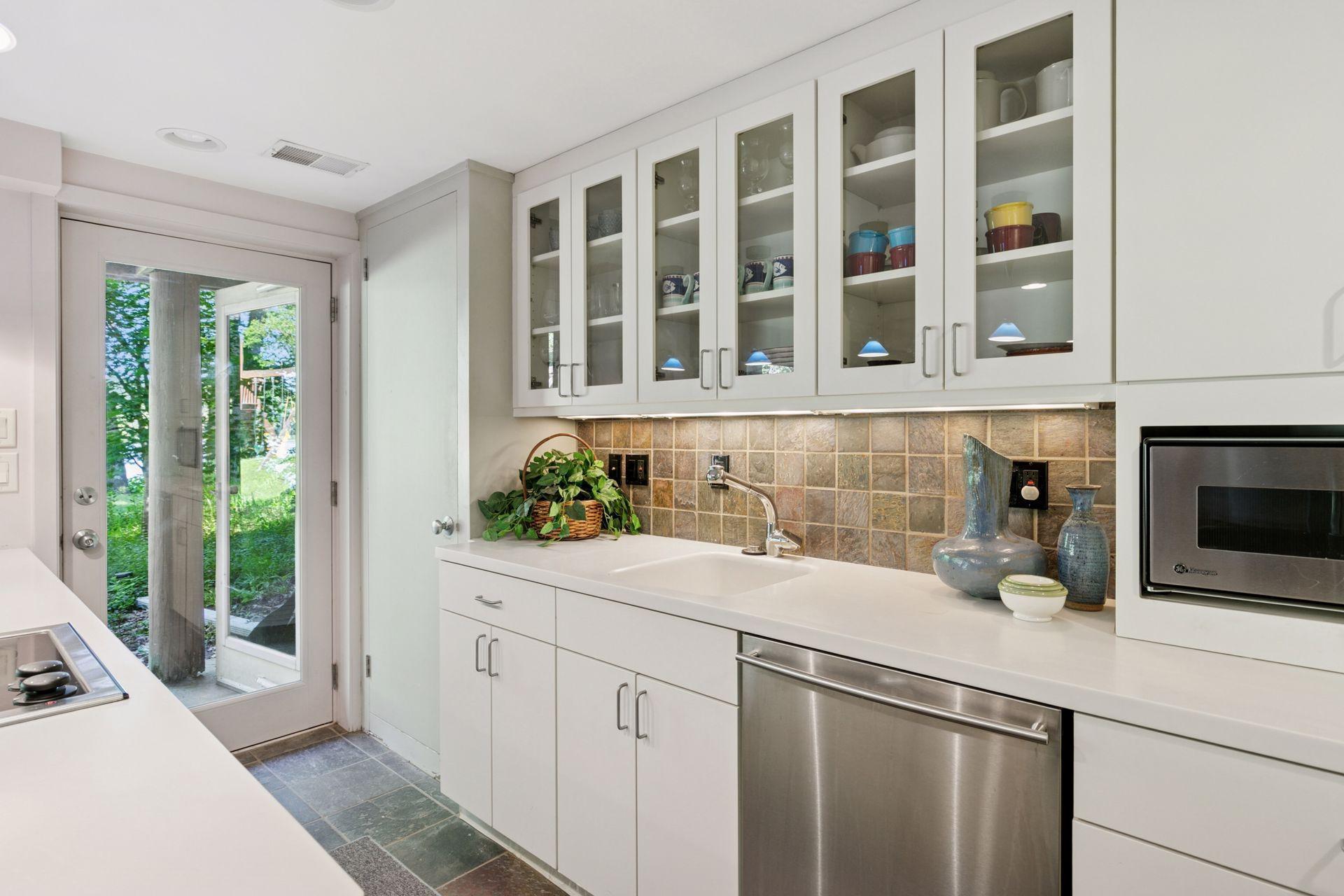 Custom cabinets provide lots of storage. Note the door to access yard and lake!