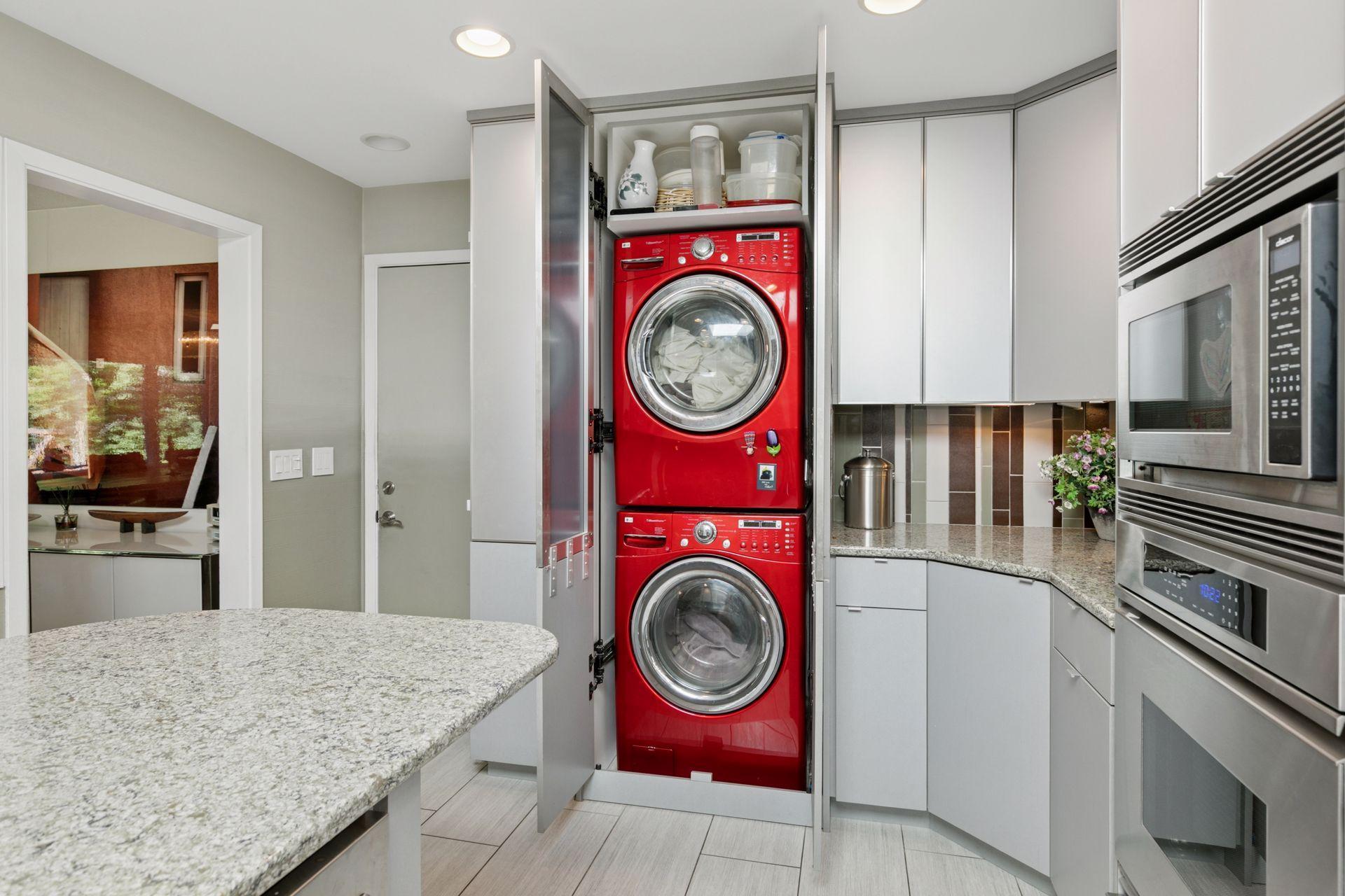 Convenient LG washer and dryer are behind custom kitchen cabinet.