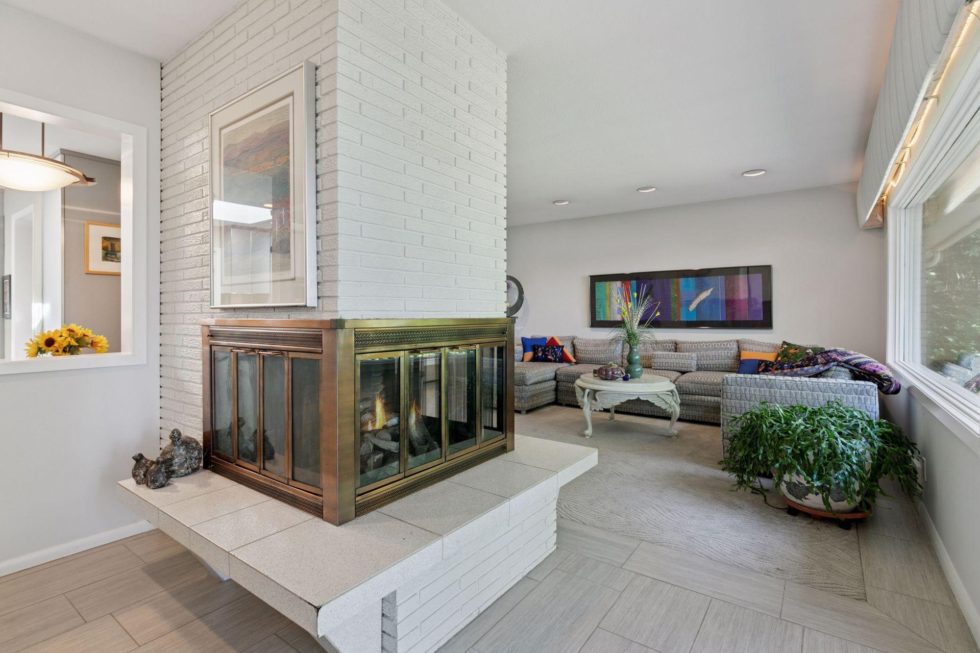 View from dining area to living room includes a triple sided fireplace.