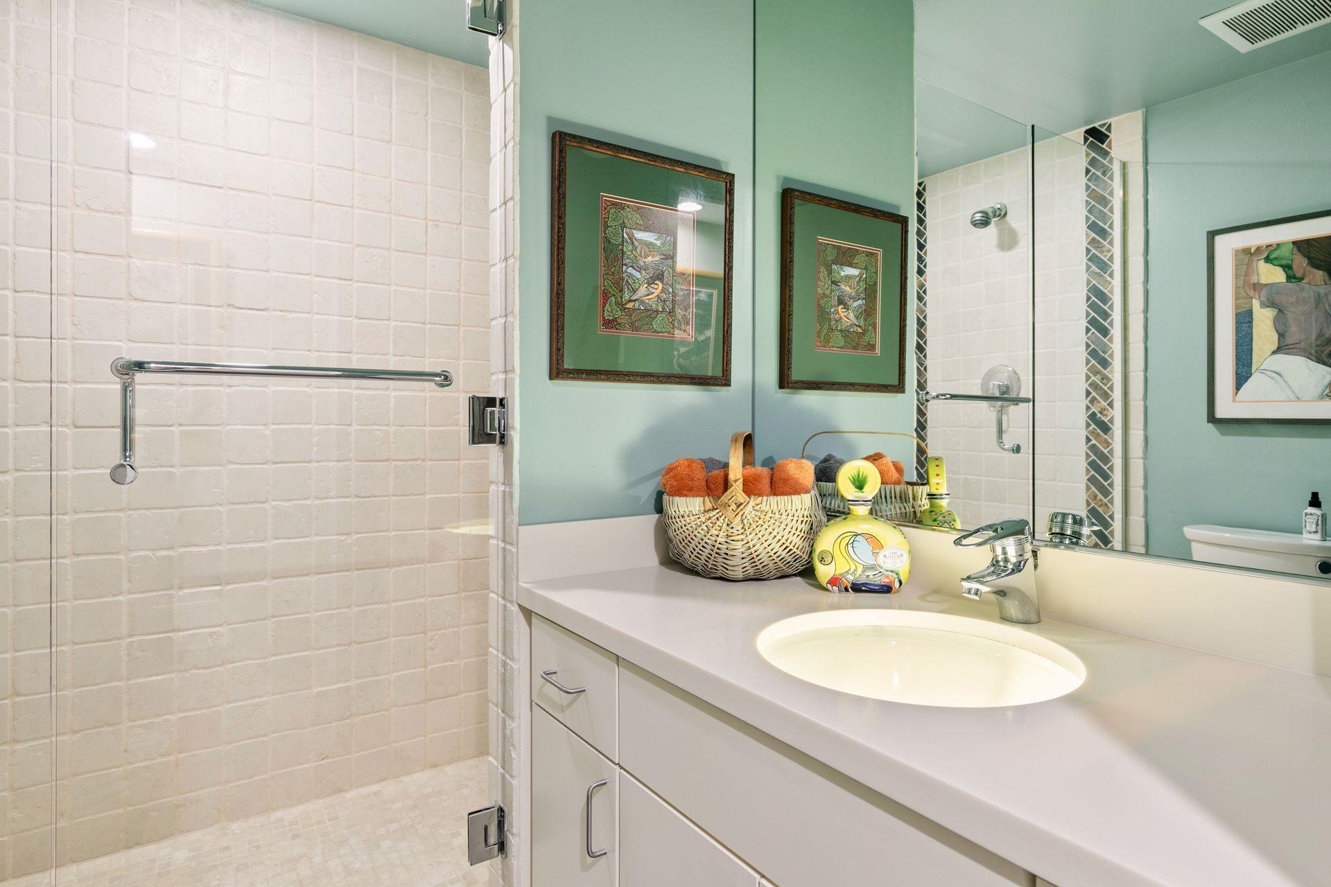 In lower level bath, unusual glass sink with backlighting. Dual shower heads too.