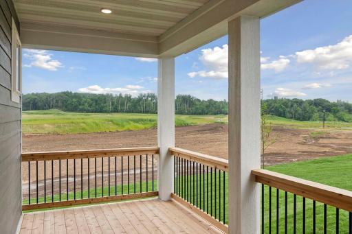 The covered deck is an inviting outdoor retreat blending seamlessly with the home and creating a harmonious connection to the outdoors. Photos are of previously built home; options & features will vary.