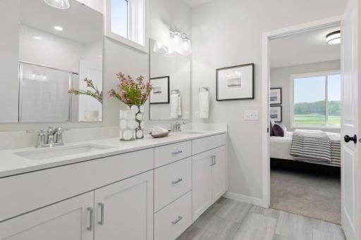 This spacious vanity not only elevates the bathroom’s aesthetic but also ensures comfort and convenience, making the ensuite a luxurious and efficient space for busy mornings. Photos are of previously built home; options & features will vary.