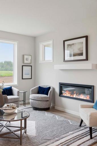 The elec. fireplace in the gathering room is a modern focal point that blends style & function. Its slim, design features a customizable LED flame display. Photos are of previously built home; options and features will vary.