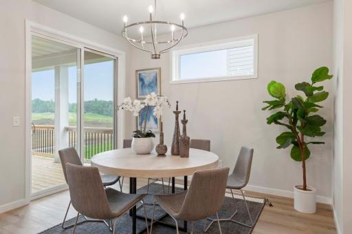 The casual dining room seamlessly extends to a covered deck, creating a perfect blend of indoor comfort and outdoor living. Photos are of previously built home; options & features will vary.