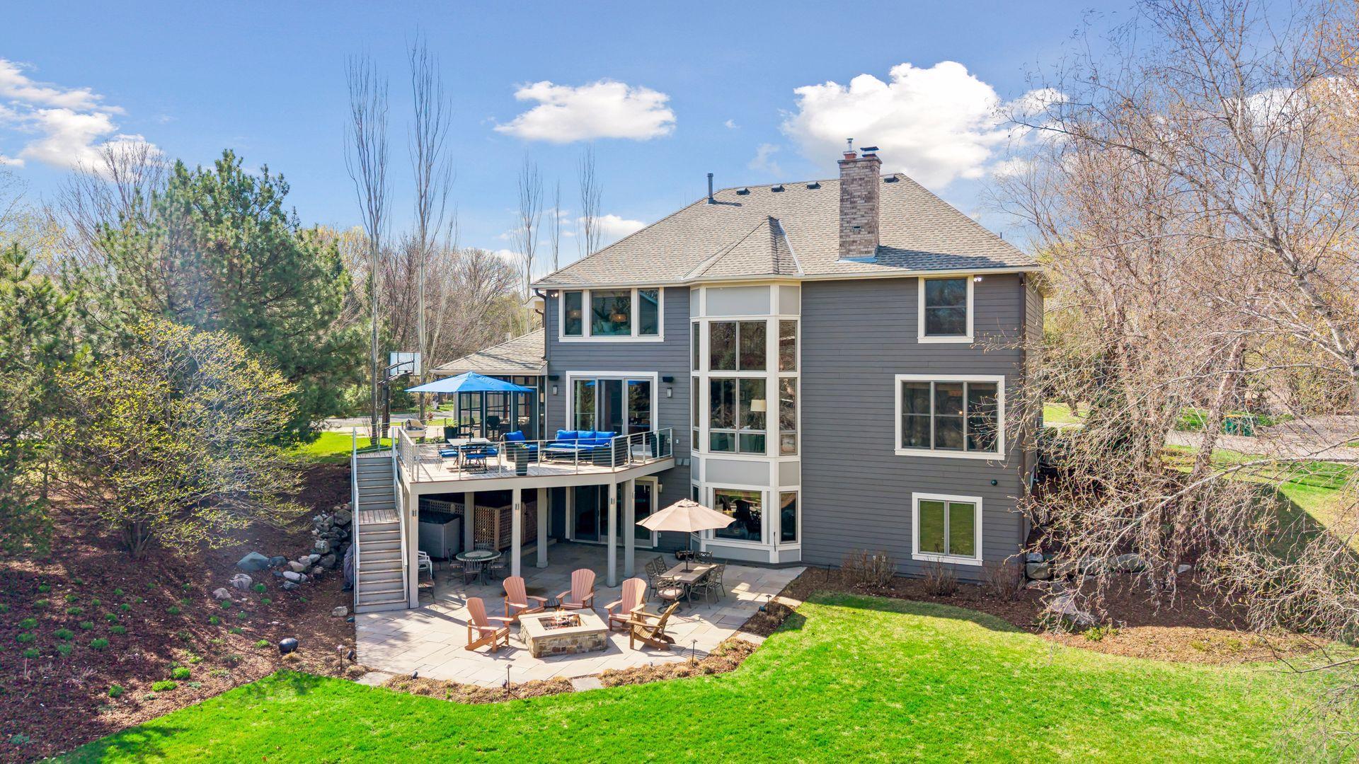 Back of home (4 sides LP Smartside), deck with stairs, exterior lighting, patio and contained storage area.