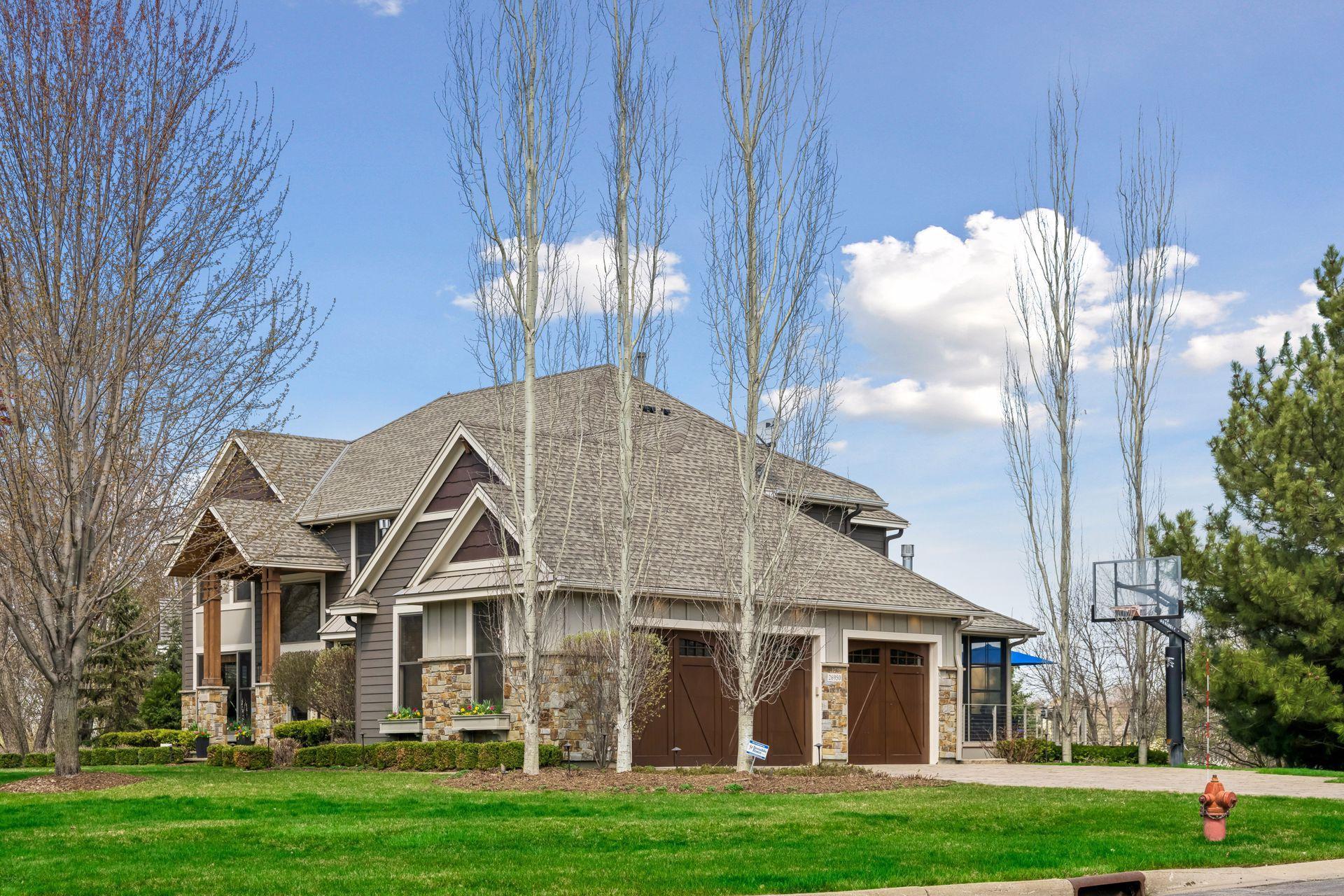 26950 Marsh Pointe Ct. Side-loading garage with handsome custom garage doors, stone paver walkways and driveway.