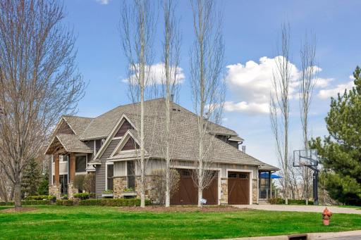 26950 Marsh Pointe Ct. Side-loading garage with handsome custom garage doors, stone paver walkways and driveway.