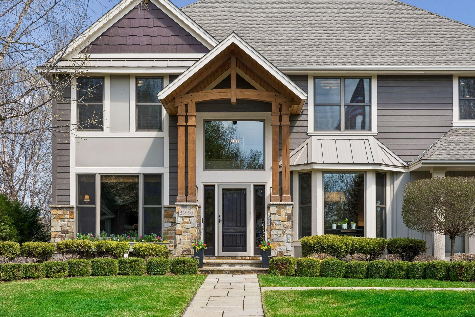 26950 Marsh Pointe Ct. Front of home has been reimagined with handsome stonework, stained cedar pillars and portico, uplighting and grand coach lighting.