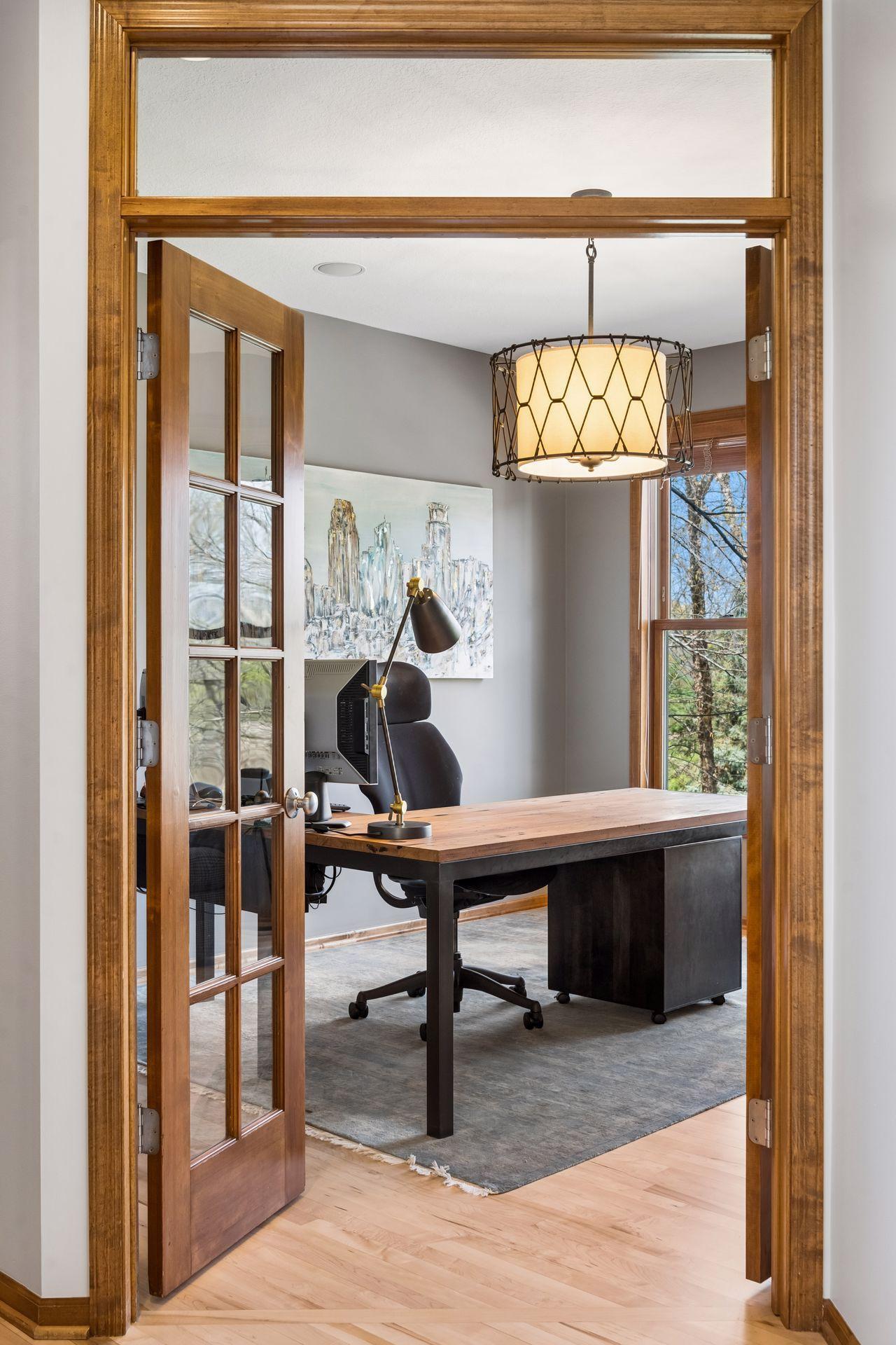 Main floor office with French doors - open to the family or closed for privacy. The view to the backyard and wetland area is inspiring.