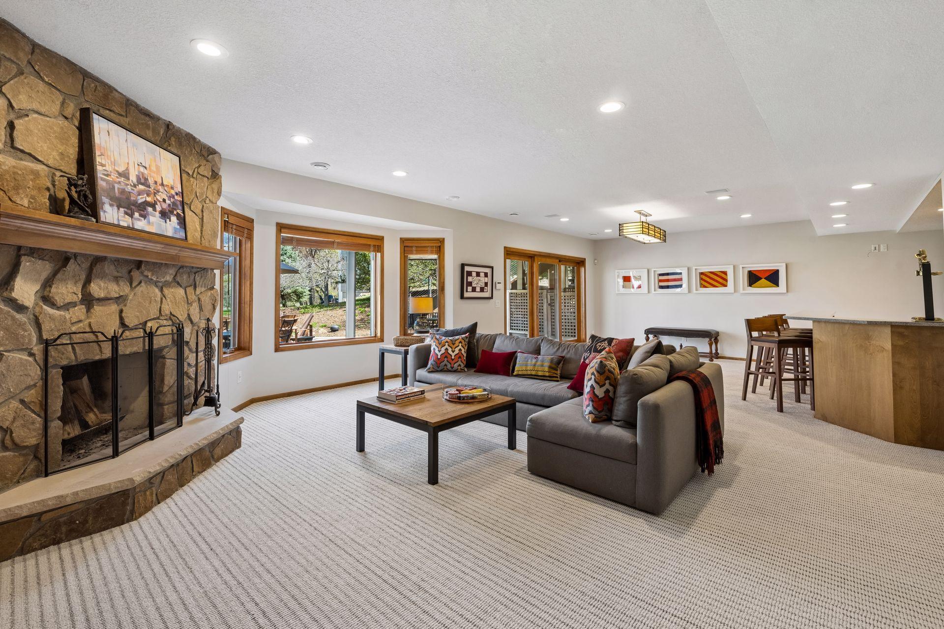 Lower level family room with wood-burning fireplace. New carpet. Wet bar with full refrigerator, dishwasher and ample cabinet space for all the goodies. Enjoy ample natural light and door to backyard and patio.
