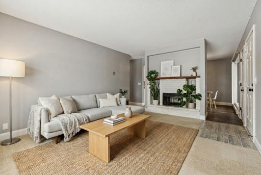 Photo for 350 Shelard Parkway, 111, Minneapolis, MN 55426 - listing #6826475 Virtually Staged Living Room- The living room serves as a warm and inviting centerpiece of the home. Large windows allow natural light to fill the space, enhancing the open feel, while the fireplace adds a cozy focal point.