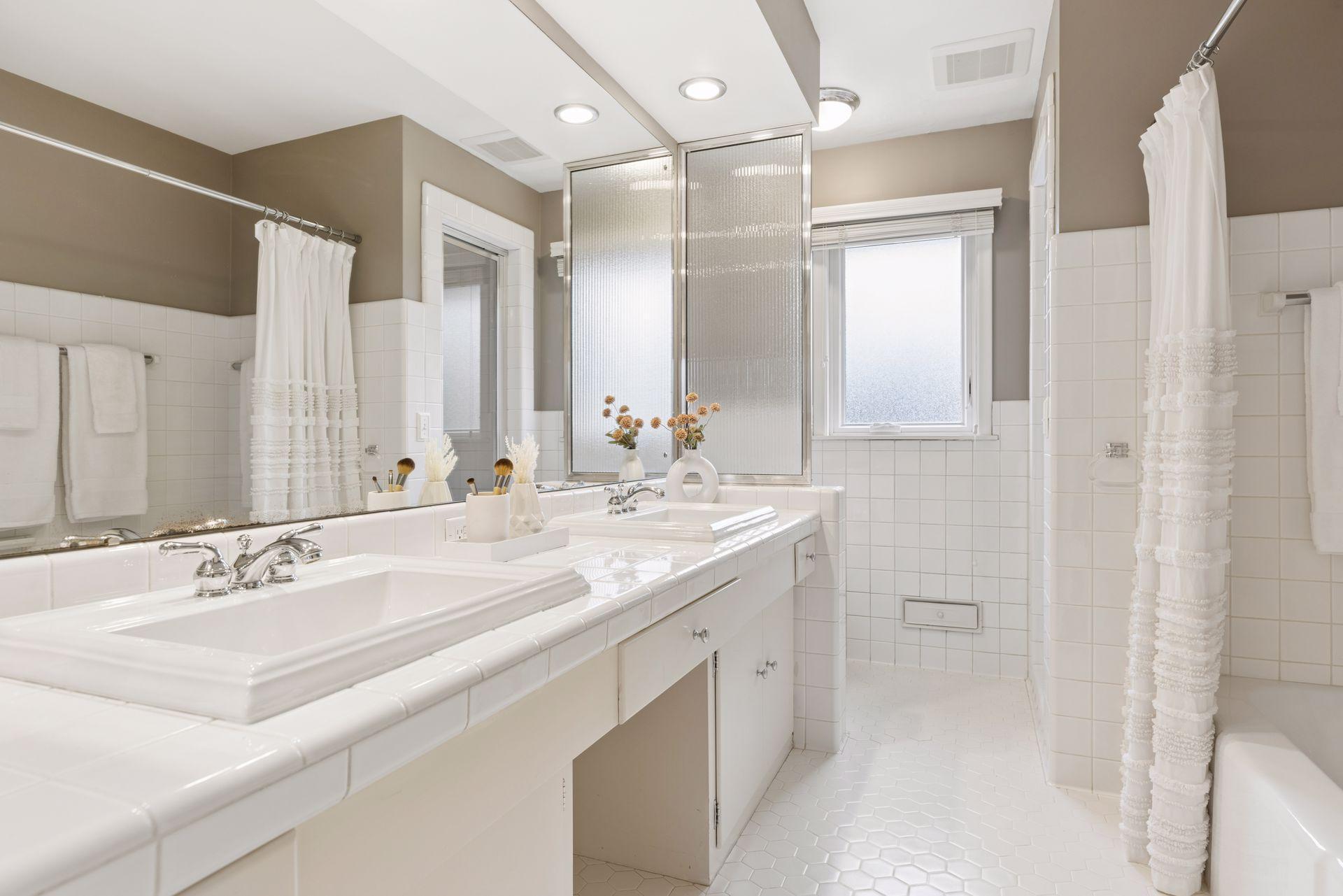 A full bathroom on the main level with a double vanity, tub, and a separate walk-in shower.