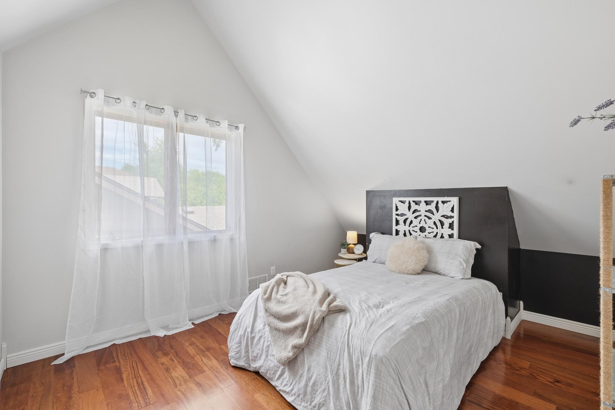 Second bedroom on the upper level with vaulted ceilings and two walk in closets