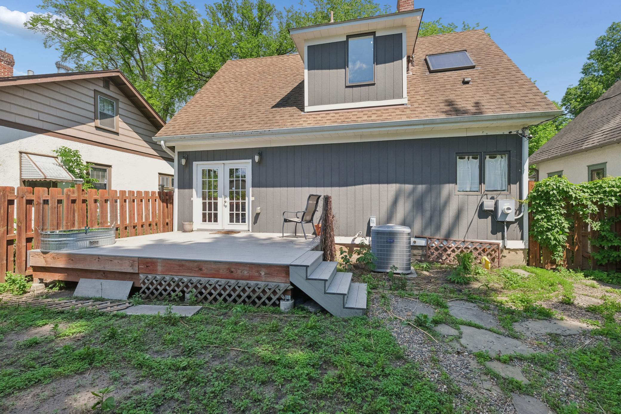 Fully Fenced backyard with stone walkway and maintenance free deck